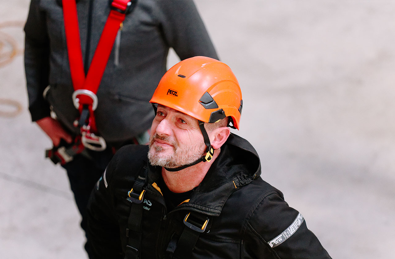 formateur en hauteur avec casque de sécurité orange